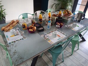 Ένα τραπέζι στρωμένο για πρωινό, με κρουασάν, χυμό και καφέ.