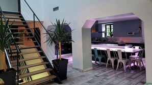 A modern interior with a staircase, a dining area, and a kitchen. - L'Hacienda (Tartas)