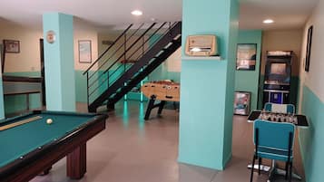 A recreational room with a pool table, foosball table, and arcade games.