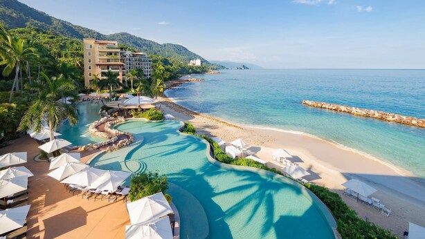 A resort with a swimming pool, beach, and mountain backdrop. - Luxury room in a 5 star Hotel in Puerto Vallarta Beaches Mex. (puerto vallarta)