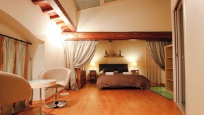 Ein Schlafzimmer mit Bett, Stuhl, Schreibtisch und Lampe.