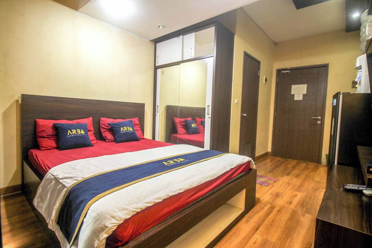 Une chambre d’hôtel comprenant un lit, une armoire, un bureau et un téléviseur.