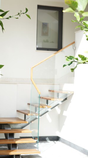 A staircase with glass railings and wooden steps, leading to an upper floor. - La Ginestra - Antheia Homes (Scafati)