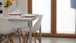 A dining area with a white table, four chairs, and a vase with yellow flowers. - La Ginestra - Antheia Homes (Scafati)