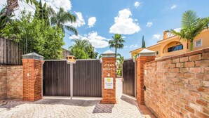 A gated entrance with a brick wall and a sign that reads "Villa Norca Grande."