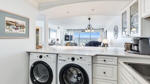 A modern kitchen with built-in washers, a large window, and a view of the city. - Beach House 201D - Gulf Front Resort! (Miramar Beach)