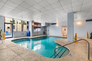 A swimming pool with a lifeguard chair, a no diving sign, and a wet floor sign. - Luxury Ocean View Condo- Relaxing Exclusive Access (Myrtle Beach)