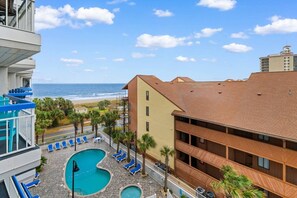 A hotel with a pool area, a view of the beach, and a multi-story building. - Luxury Ocean View Condo- Relaxing Exclusive Access (Myrtle Beach)
