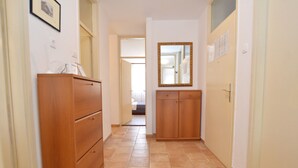 Ein Flur mit Holzschränken, einem Spiegel und einem Bett im Hintergrund.
