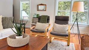 A modern living room with a wooden coffee table, two armchairs, a sofa, and a floor lamp. - The Ingalls House - Downtown (Harbor Springs)