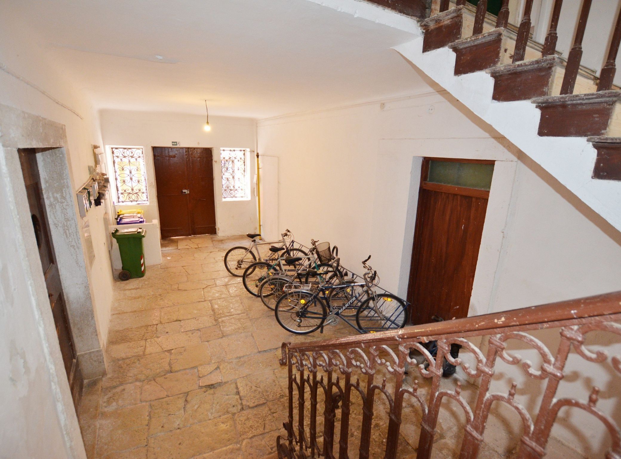A staircase leading to a landing with multiple bicycles parked.