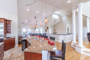 A spacious kitchen with a large island, modern appliances, and pendant lighting.