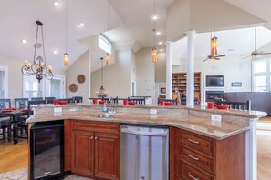 A spacious kitchen with a large island, built-in appliances, and pendant lighting.