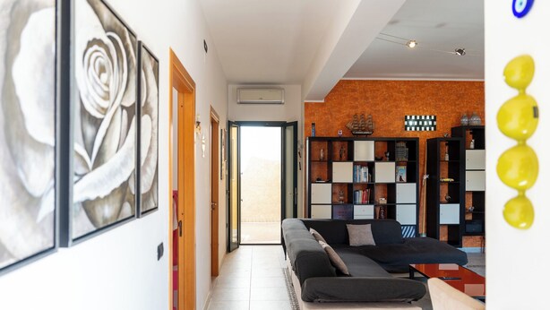 A modern living room with a sofa, a coffee table, and a bookshelf. - Sophie (Cellino San Marco)