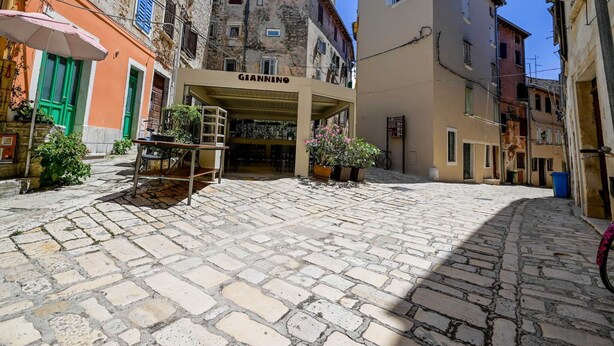 A cobblestone street with a building labeled "GIANNINO" in the center. - Snug and Stylish Downtown Rovinj Apartment (Rovinj)