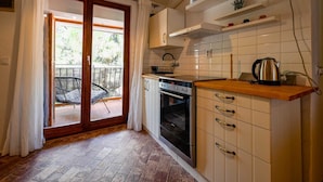 A kitchen with a built-in oven, a coffee maker, and a window overlooking a balcony. - Snug and Stylish Downtown Rovinj Apartment (Rovinj)