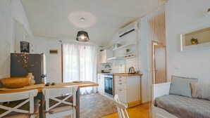 A compact living space with a kitchen, dining area, and a sofa. - Snug and Stylish Downtown Rovinj Apartment (Rovinj)
