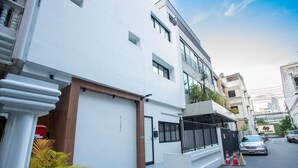 A modern two-story residential building with a white facade, a wooden door labeled "THONGLOR," and a small balcony. - Dado9 (Bangkok)