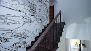 A staircase with a mural of traditional architecture. - Dado9 (Bangkok)