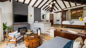 Ein modernes Wohnzimmer mit Kamin, einer Couch, einem Couchtisch und einem an der Wand montierten Fernseher.