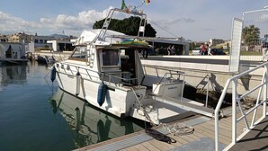Un bateau était amarré dans une marina, avec un pont en bois et des garde-corps en métal.