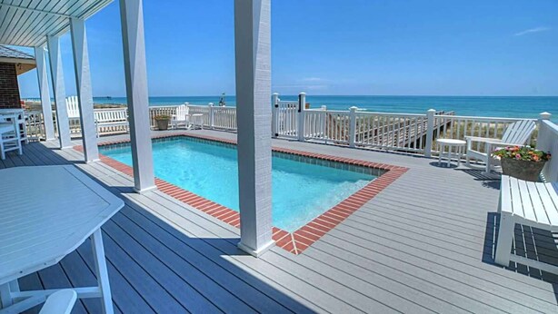 A poolside area with a view of the ocean, deck chairs, and a pool. - Big Bird -7br-Oceanfront-Heated Pool-Elevator (Kure Beach)