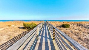 A wooden boardwalk leading to a beach with dry grass on either side. - Big Bird -7br-Oceanfront-Heated Pool-Elevator (Kure Beach)