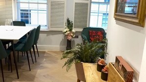 A dining area with a wooden table and chairs, a bench, and a potted plant. - London Charm - Central London Apart Soho Mayfair (London)