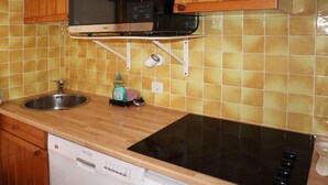 Une cuisine équipée d’un lave-vaisselle, d’un four à micro-ondes, d’une cuisinière et d’un évier.
