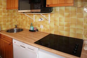 A kitchen with a dishwasher, a microwave, a stove, and a sink.