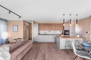A modern kitchen with a central island, white cabinets, and pendant lighting. - Apartment Near Beach With sea View (Brtonigla)