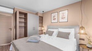 A modern bedroom with a large bed, a wardrobe, and a bedside table with a lamp. - Apartment in Pula With Sea View and Bubble Bath (Brtonigla)