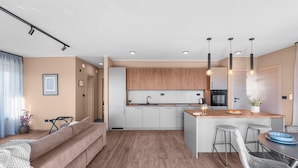 A modern kitchen with a central island, white cabinets, and a wooden countertop. - Apartment in Pula With Sea View and Bubble Bath (Brtonigla)