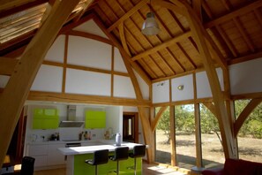 A kitchen with a central island, bar stools, and a view of the outdoors. - Peaceful Nature Retreat in Othery (Bridgwater)