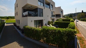 A modern two-story residential building with large windows, a balcony, and a well-maintained garden. - Family Friendly Spacious Apartment With Garden and Terrace (Rovinj)