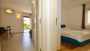A bedroom with a bed, a desk with chairs, and a view of the outside. - Family Friendly Spacious Apartment With Garden and Terrace (Rovinj)