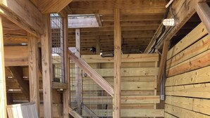 Ein Holzinnenraum mit Treppe, einer Bank und einem Tisch.