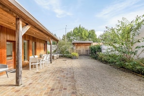 A patio area with a brick floor, wooden deck, and outdoor furniture. - Coolhuys , your home in Bruges away from home.  (Brugge)