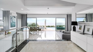 A modern hotel room with a glass door leading to a balcony with a pool view.