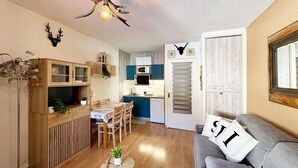 A compact living space with a kitchenette, a dining area, and a seating area with a sofa. - 10m from ski slopes, 4th floor, view ski slopes, balcony, tv, 22m², Les Orres (Les Orres)