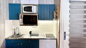 A compact kitchen with blue cabinets, a microwave, a sink, and a dishwasher. - 10m from ski slopes, 4th floor, view ski slopes, balcony, tv, 22m², Les Orres (Les Orres)
