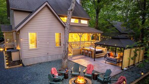 A house with a patio area featuring outdoor seating and a fire pit.