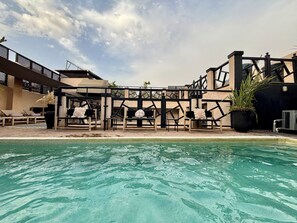 A pool area with lounge chairs and a pergola structure.