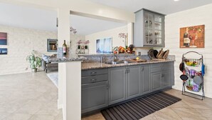 A modern kitchen with grey cabinets, a granite countertop, and a built-in oven. - On Omni La Costa Golf Course- Patio, Parking, & AC (Carlsbad)