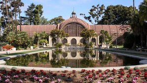 A building with a large central dome and arched windows, surrounded by a reflecting pool and palm trees. - On Omni La Costa Golf Course- Patio, Parking, & AC (Carlsbad)