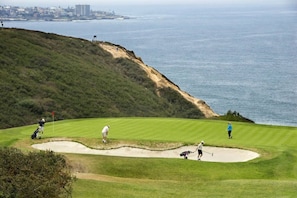A golf course with a coastal view, a sand bunker, and a flagstick. - Enci Rental - Pool Table, BBQ, 10 MinsTo Beach (Encinitas)