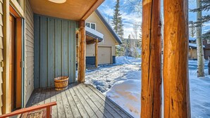 Un pontile in legno con vista su una casa e un paesaggio innevato.