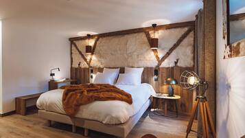 A modern bedroom with a large bed, wooden headboard, and a fur-like wall covering. There are bedside tables with lamps and a floor lamp.
