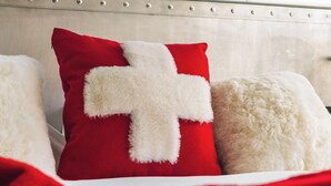 A bed with red and white pillows, a red cable car in the background, and a snowy mountain landscape. - Grand Hôtel l'Ermitage Font-Romeu - Handwritten Collection (Font-Romeu-Odeillo-Via)