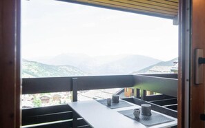 A balcony with a view of mountains, a table with two cups, and a wooden railing. - 5m from ski slopes, 2nd floor, view valley, balcony, tv, 25m², Valmorel (Valmorel)
